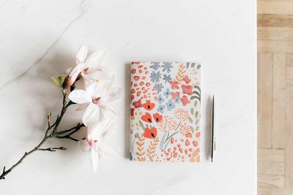 Notebook and flowers on a bright desk